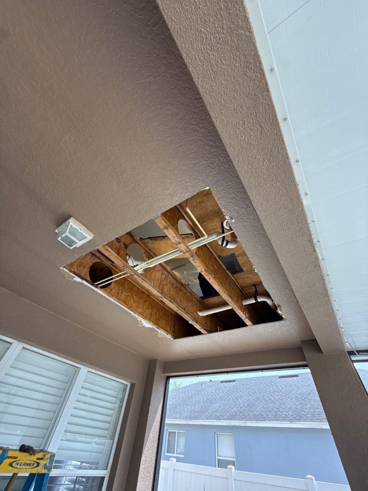 Ceiling opened up to expose water damage and framing during restoration work